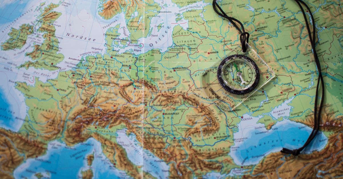 A compass placed on a detailed map of Europe showcasing travel and exploration themes.